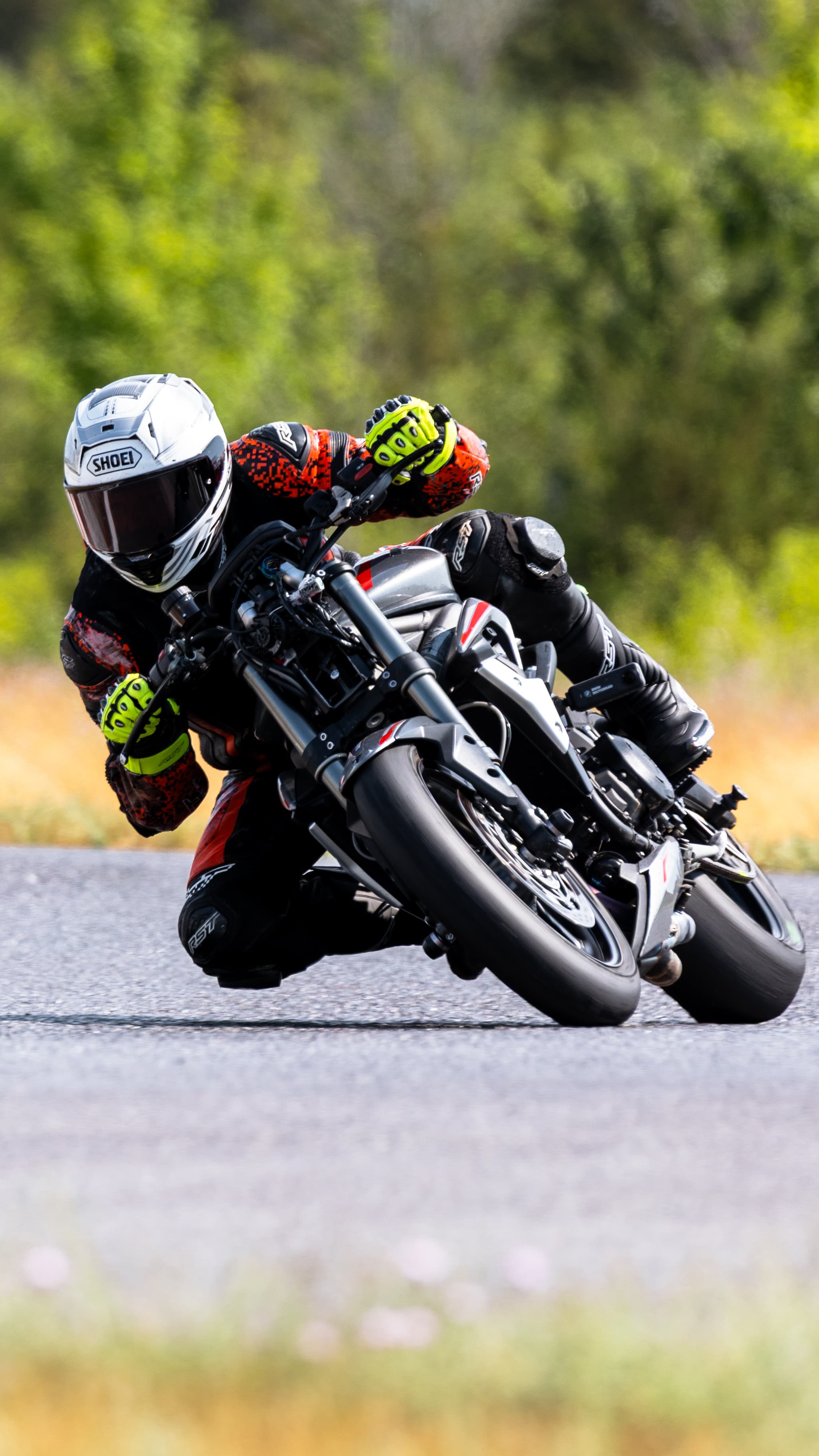 A rider in a white helmet leaning a motorcycle into a corner.