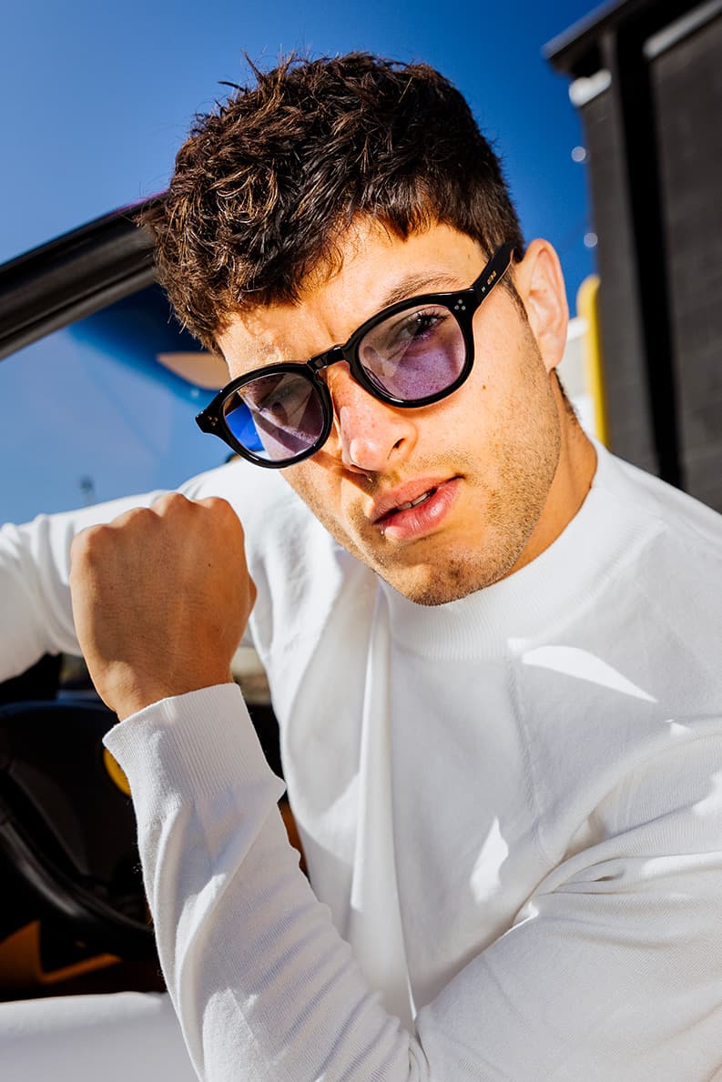 Close portrait of a model wearing dark-framed Waid sunglasses.