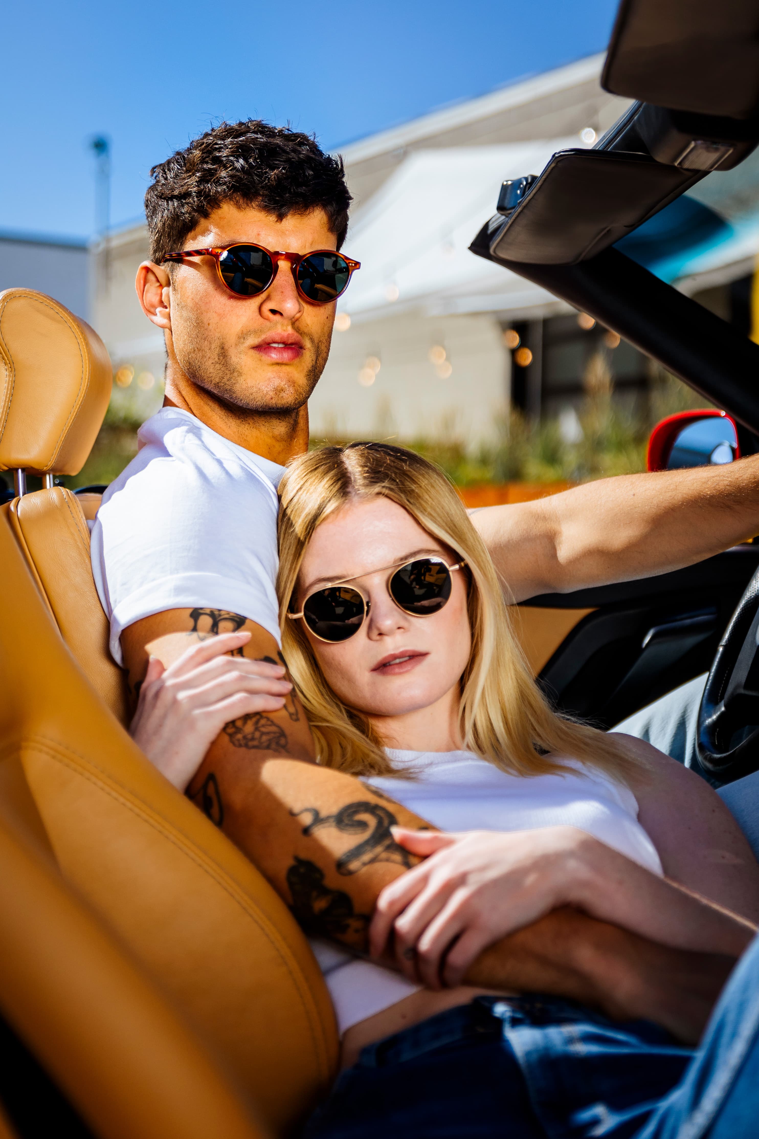 Two models wearing Waid sunglasses in a convertible.
