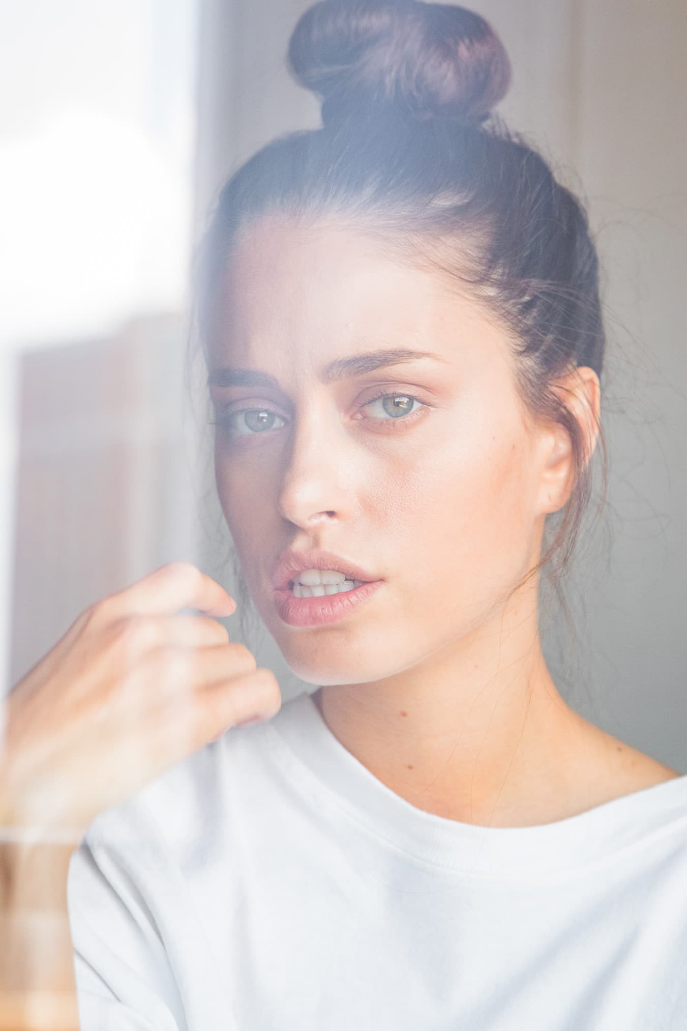 Close portrait of Chloe through softly reflective window glass.