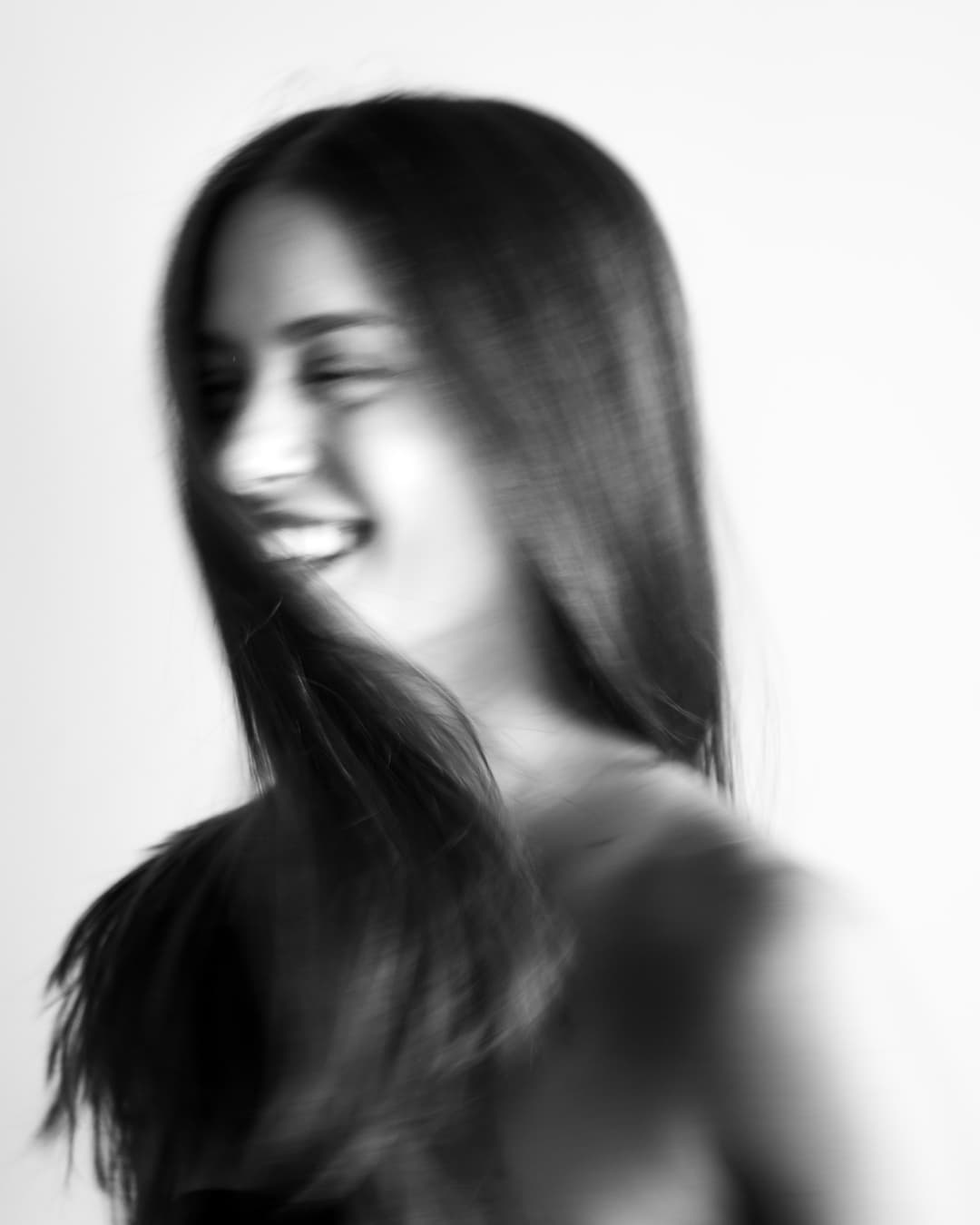 Black-and-white portrait of Chloe smiling in motion.
