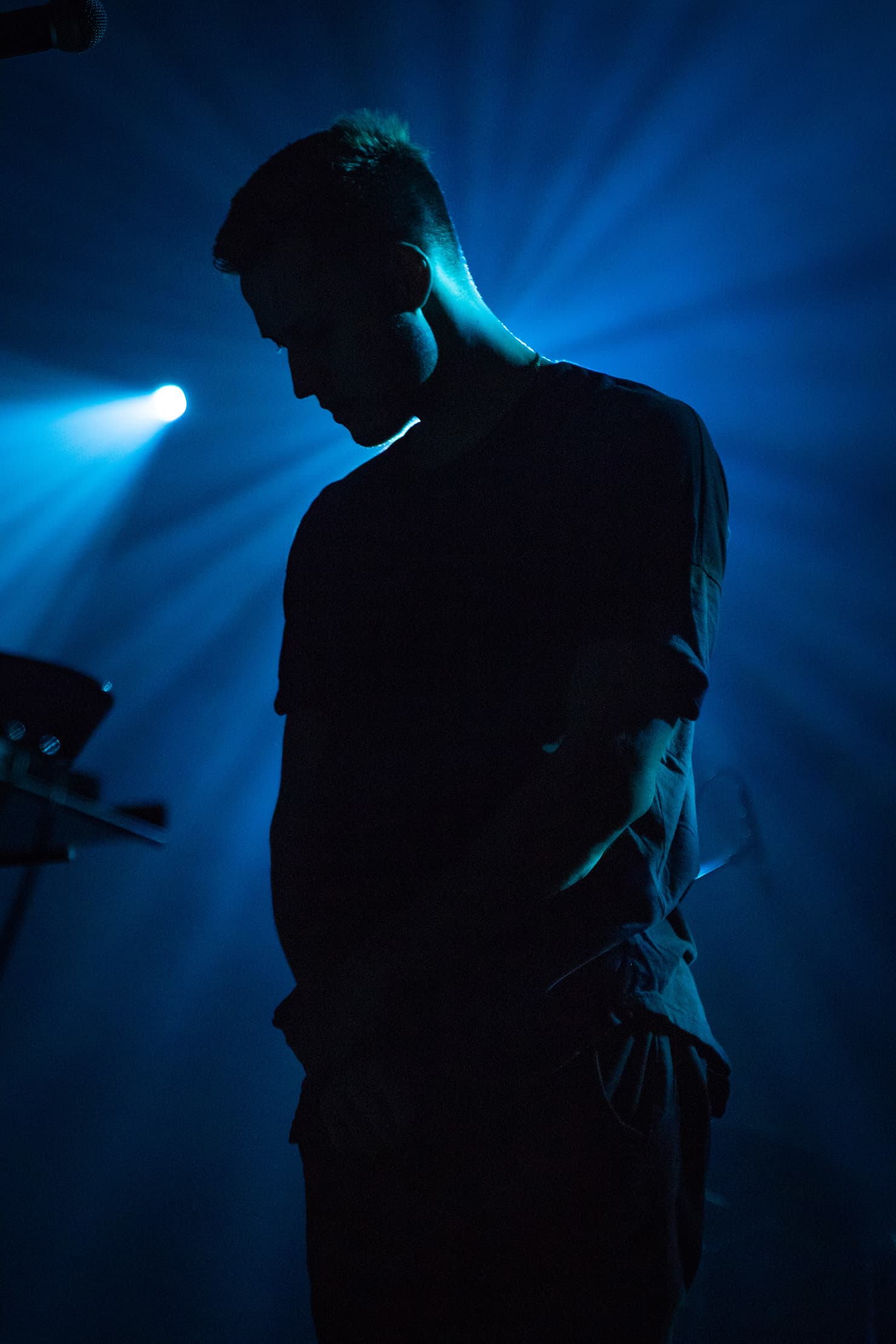 A musician silhouetted against blue stage lighting.