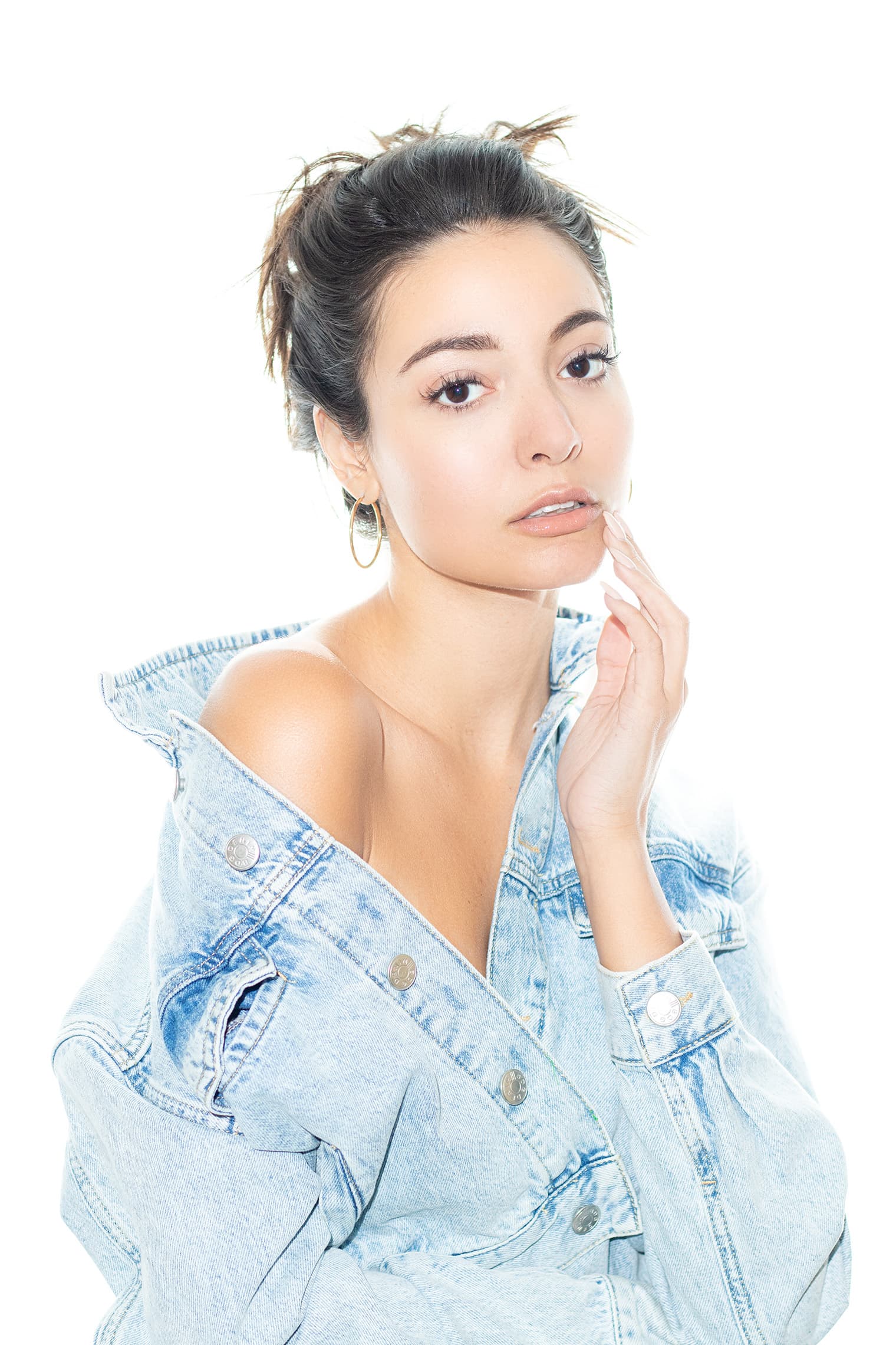 Natalie in a denim jacket against a bright studio background.